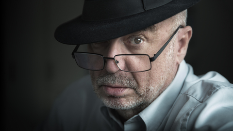 Portrait of serious looking senior man wearing glasses and hat stock photo