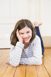 Portrait of laughing girl lying on the floor - LVF06500