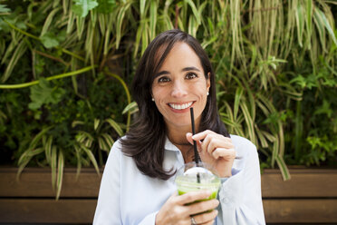 Women drinking green juice, detox, plastic cup - VABF01388