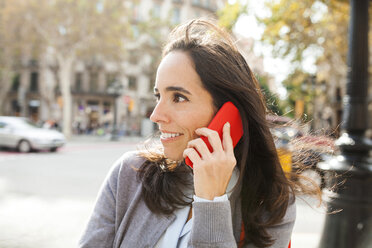 Smiling woman on cell phone in the city - VABF01407