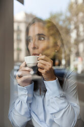 Geschäftsfrau trinkt Espresso hinter Fensterscheibe - VABF01410