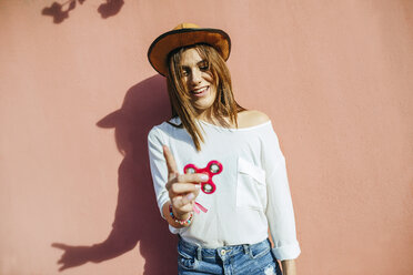 Portrait of laughing young woman with fidget spinner - KIJF01765