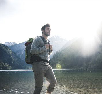 Österreich, Tirol, junger Mann beim Wandern am Bergsee - UUF12470