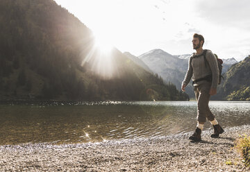 Österreich, Tirol, junger Mann beim Wandern am Bergsee - UUF12475