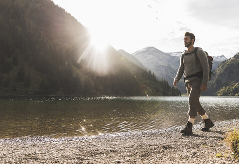 Österreich, Tirol, junger Mann beim Wandern am Bergsee - UUF12475