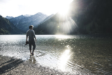 Österreich, Tirol, Wanderer erfrischt sich in Bergsee - UUF12489