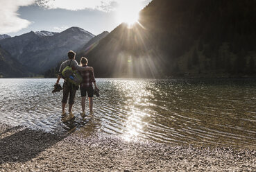 Österreich, Tirol, wanderndes Paar erfrischt sich im Bergsee - UUF12490