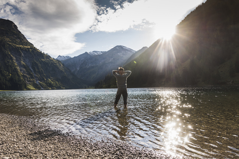 Austria, Tyrol, hiker refreshing in mountain lake stock photo