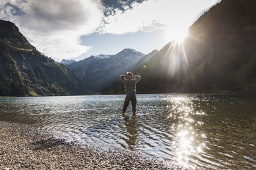 Austria, Tyrol, hiker refreshing in mountain lake - UUF12491