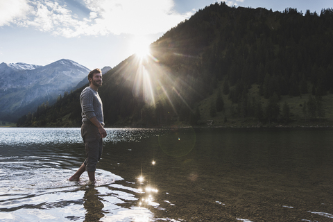 Österreich, Tirol, Wanderer erfrischt sich in Bergsee, lizenzfreies Stockfoto