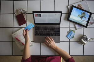 Junge Frau benutzt Laptop, bezahlt mit Kreditkarte, Reisebuchung - MOMF00339