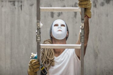 Mann mit Maske, der mit einem Seil und einer Spraydose auf eine Leiter steigt - ZEF14871