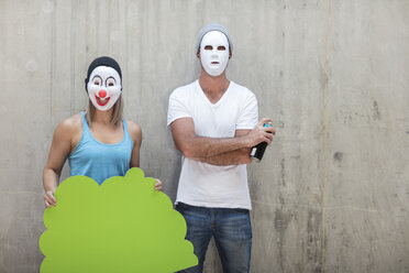 Mann und Frau mit Masken stehen neben einer Betonwand - ZEF14882