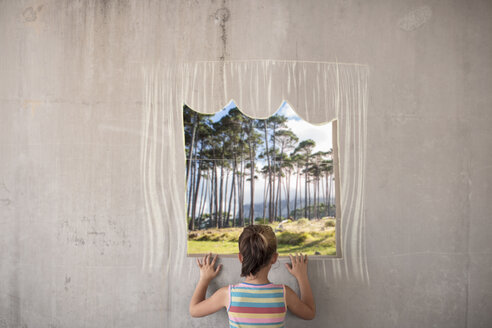 Mädchen hält ein Bild eines Waldes an einer Betonwand mit einem mit Kreide gezeichneten Rand - ZEF14895