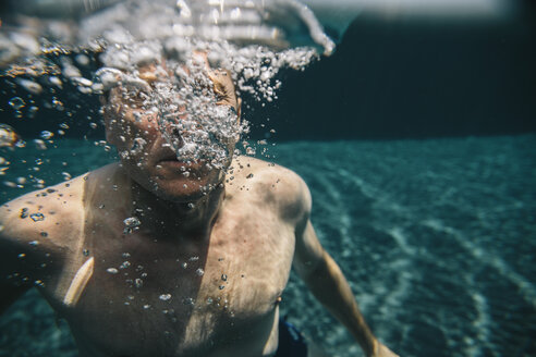 Mann macht Luftblasen unter Wasser in einem Schwimmbad - MFF04229