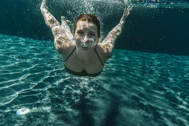 Porträt einer glücklichen Frau beim Tauchen in einem Schwimmbad - MFF04241