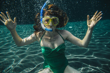 Portrait of woman with diving goggles and snorkel underwater in a swimming pool - MFF04251
