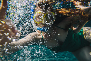 Portrait of woman with diving goggles and snorkel underwater in a swimming pool - MFF04252