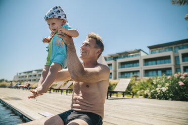 Happy father and baby son at the poolside during summer vacation - MFF04267