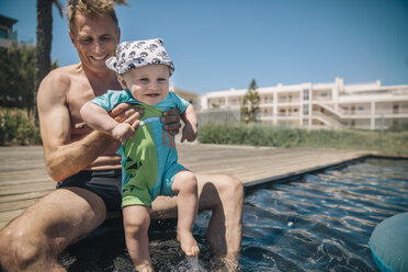 Vater und kleiner Sohn testen Wasser im Schwimmbad während der Sommerferien - MFF04268
