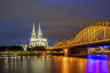 Germany, Cologne, illuminated Cologne Cathedral and Hohenzollern bridge at night - PUF00973