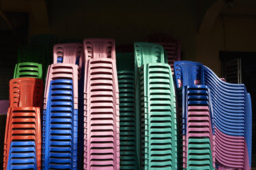 Stacks of coloured plastic chairs - IGGF00248