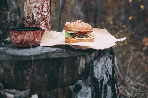 Burger und Becher mit Tee auf Briefmarke, lizenzfreies Stockfoto
