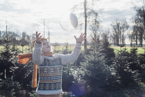 Little boy throwing a snow-filled crystal ball stock photo