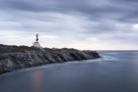 Spanien, Balearische Inseln, Menorca, Leuchtturm von Favaritx umgeben von Wolken am Morgen, lizenzfreies Stockfoto