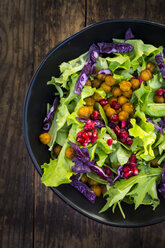 Bowl of mixed leaf salad with pomegranate seed, red cabbage and roasted curcuma chick peas - LVF06521