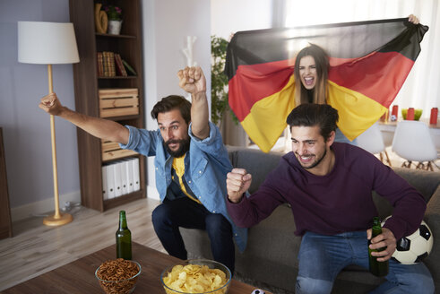 Begeisterte deutsche Fußballfans, die fernsehen und jubeln - ABIF00070