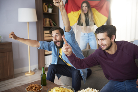 Excited German football fans watching Tv and cheering stock photo