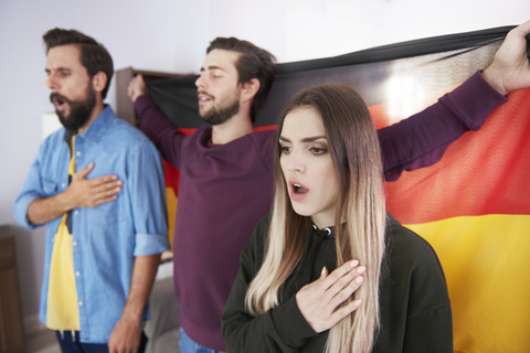 Football fans with German flag singing national anthem stock photo