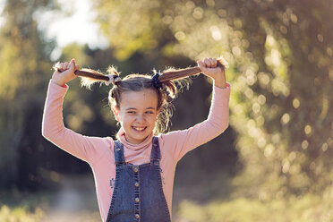 Porträt eines lachenden Mädchens, das an ihren Haaren zieht - XCF00165