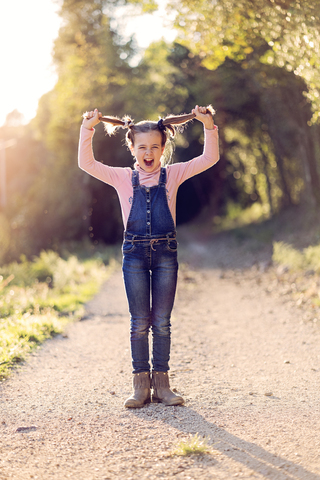 Porträt eines schreienden Mädchens, das an ihren Haaren zieht, lizenzfreies Stockfoto