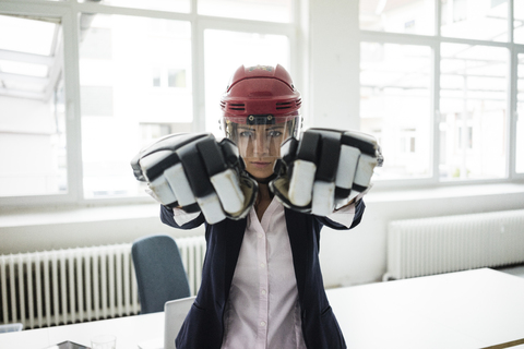 Portrait of businesswoman wearing ice hockey equipment stock photo