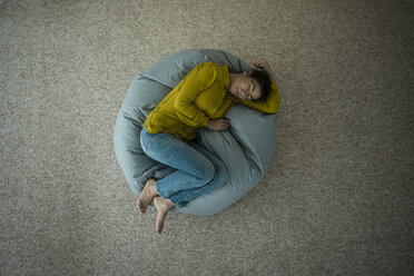Woman sleeping on bean bag at home, top view - MOEF00500