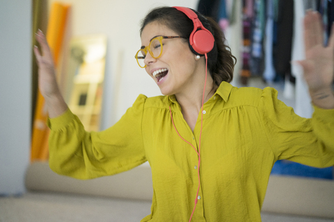 Frau hört Musik mit Kopfhörern, singt und tanzt, lizenzfreies Stockfoto