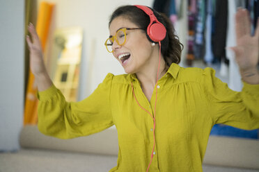 Woman with listening music with headphones singing and dancing - MOEF00503