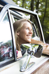 Happy young woman in car in forest - FKF02801