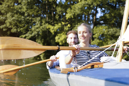 Young couple enjoying a trip in a canoe on a lake - FKF02826