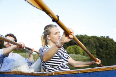 Young couple enjoying a trip in a canoe on a lake - FKF02830