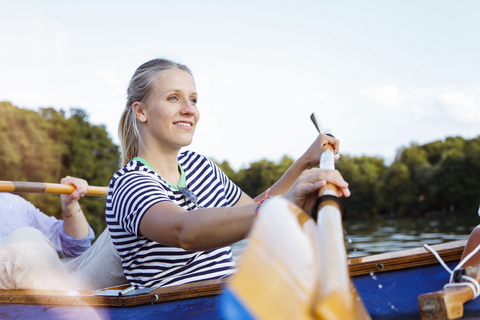 Young couple enjoying a trip in a canoe with sail on a lake stock photo
