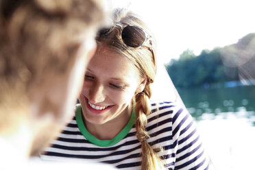 Smiling young woman with man at a lake - FKF02838