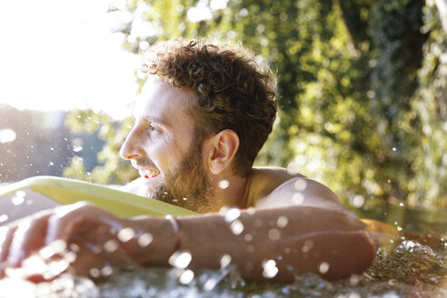 Happy young man with surfboard in a lake - FKF02843