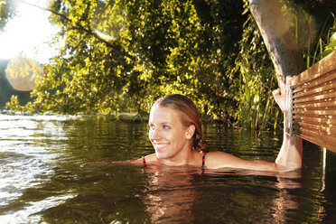 Happy young woman in a lake - FKF02848