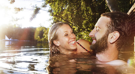 Happy young couple in a lake - FKF02850