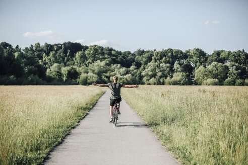 Junger Mann auf einem Fahrrad, freihändig - GUSF00288