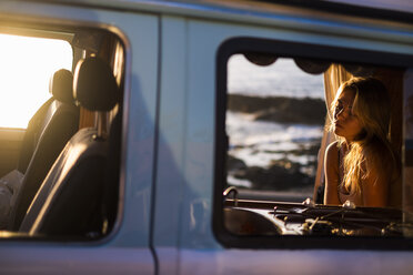 Spanien, Teneriffa, Blondes Mädchen sitzt in einem Van bei Sonnenuntergang - SIPF01879