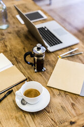 Laptop and coffee on table at home - GIOF03594